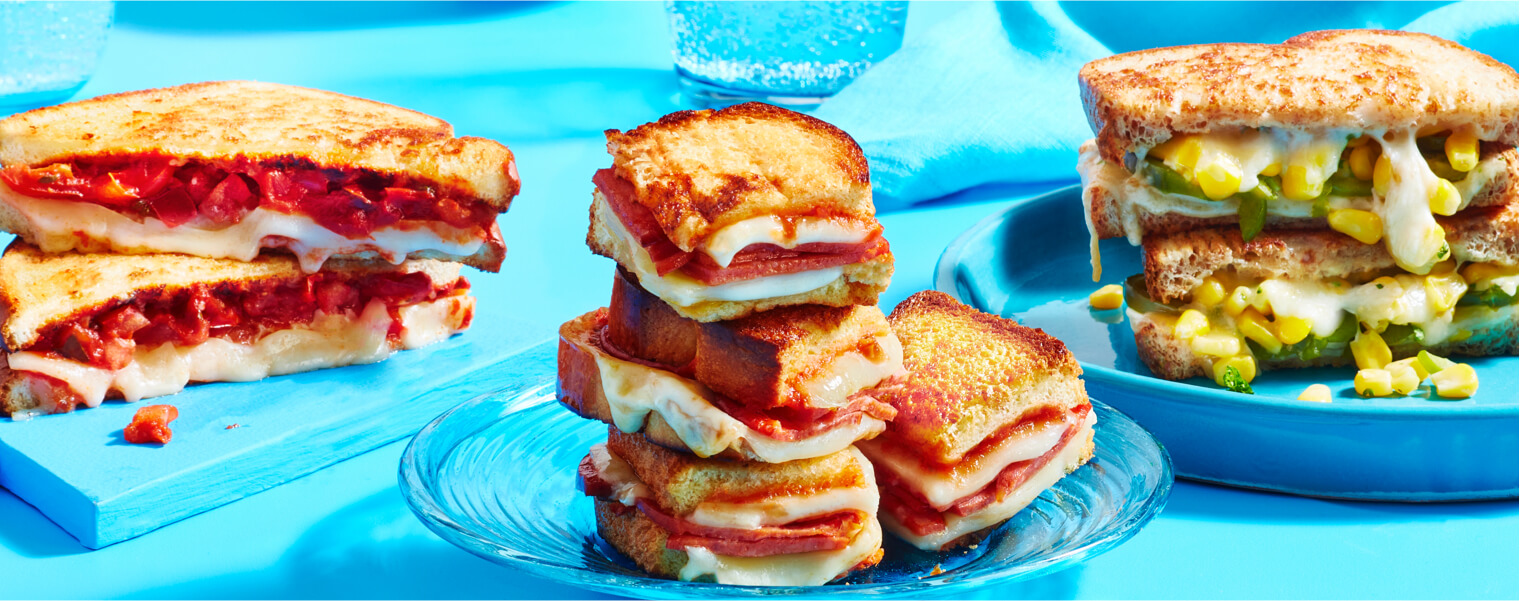 Cheesy-corn-grilled-cheese Salsa grilled cheese sandwich, pizza grilled cheese sandwich, ad corn-herb grilled cheese sandwich on blue plates