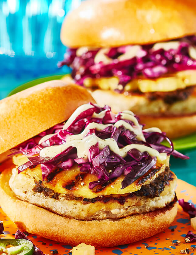 9 façons de mettre en vedette les_sauces à burger Burger d'inspiration caribéenne sur assiette orange.